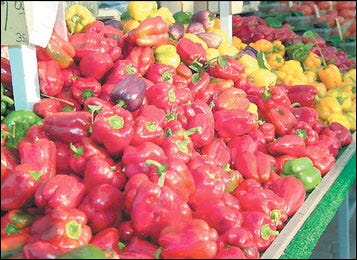 Michigan-grown bell peppers, left, and strawberries on display for sale at the Holland Farmers Market in 2010. The popular downtown market returns for the 2011 season Wednesday.
