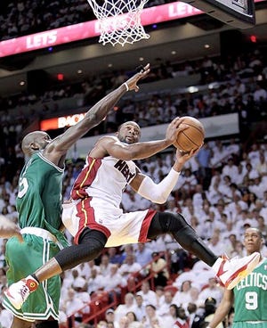 Miami Heat guard Dwyane Wade, right, goes up for a shot against Boston Celtics center Kevin Garnett during the first half of Wednesday's playoff game in Miami. 
By WILFREDO LEE, The Associated Press