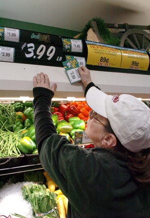 Diana Wright changes the produce signs at Trucchi's supermarket in Abington on Friday, jan. 21, 2011.