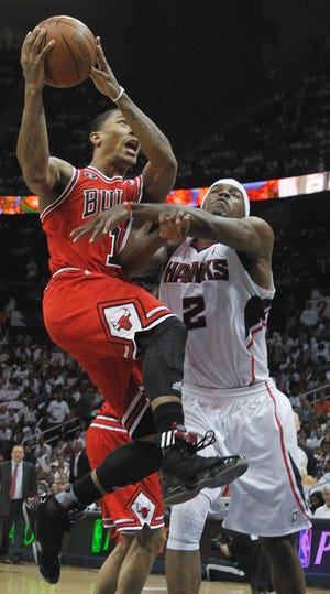 Chicago Bulls point guard Derrick Rose (1) goes to the basket as Atlanta Hawks shooting guard Joe Johnson (2) defends in the third quarter of Game 6 of an NBA basketball Eastern Conference semifinal playoff series, Thursday, May 12, 2011, in Atlanta. (AP Photo/John Bazemore)