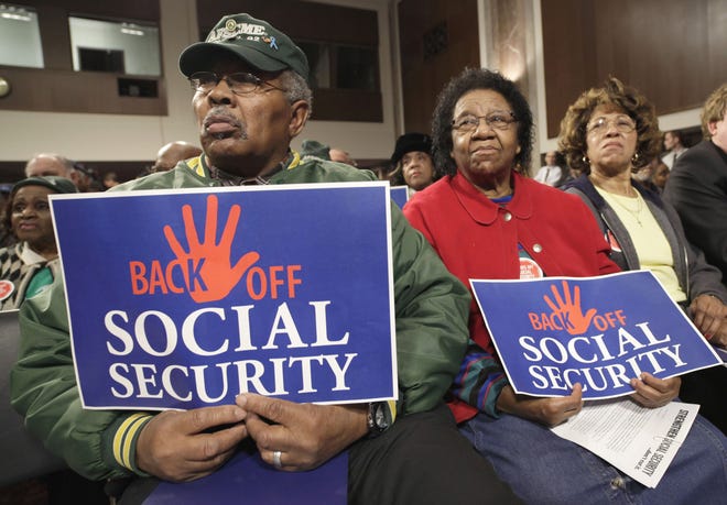 Eddie Bostic of Baltimore, left, and other audience members, listen to Democratic senators speak at a "Back Off Social Security" rally on Capitol Hill in Washington, Monday, March 28, 2011. (AP Photo/J. Scott Applewhite)