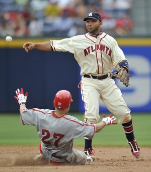 The Phillies' Placido Polanco (27) breaks up an attempted double play as Atlanta Braves shortstop Alex Gonzalez relays to first during the ninth inning of the game on Saturday in Atlanta. The Braves won 5-3.