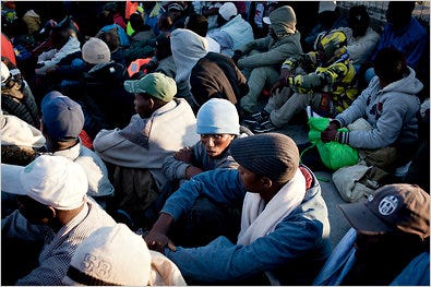 Some of the hundreds of refugees from Libya who arrived Friday by boat in Lampedusa, Italy, waited to be sent to a holding center.