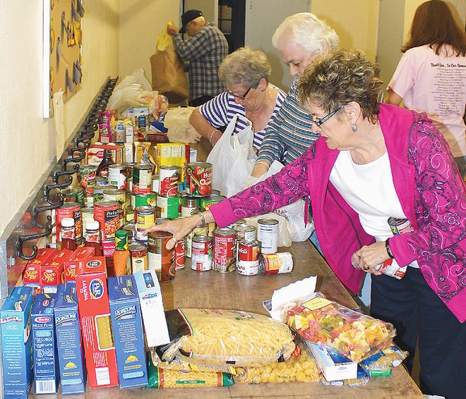 Ilion-Frankfort Food Pantry volunteers Dawn Hosney, far right, Joanne Amato, center, and Peggy Blumenstock, all of Frankfort, receive donated food items from the Staff Sgt. John LaPolla Memorial Food Drive in Frankfort Saturday morning. The collection included items for a food drive conducted by the local post office as well.