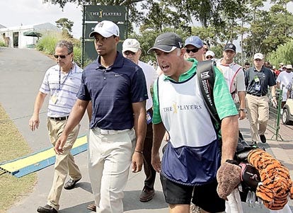 Tiger Woods, second from left, and caddie Steve Williams leave the course after nine holes during the first round of The Players Championship Thursday. By CHRIS O'MEARA, AP