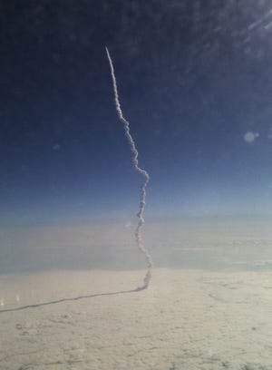 This citizen journalism photo taken with a cell phone by Stefanie Gordon aboard a passenger flight from New York to Palm Beach, Fla. shows the space shuttle Endeavor as it streaks toward orbit shortly after liftoff Monday May 16, 2011. Gordon says she had just awakened from a nap on the flight when the pilot announced the shuttle might come into view.