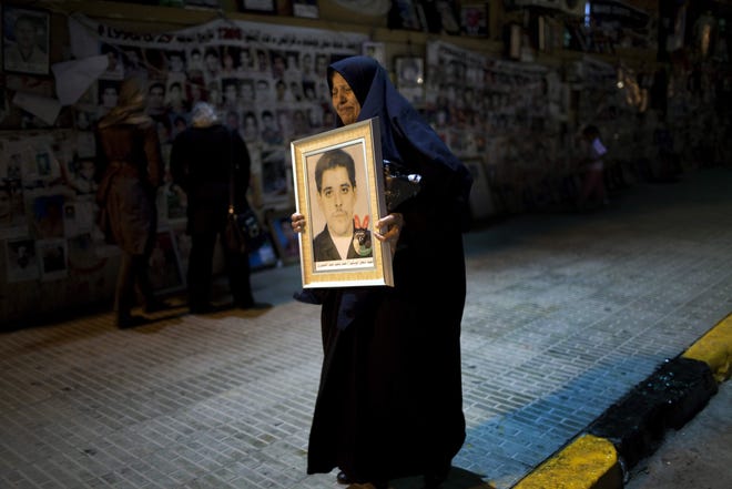 Mabroka Kwafi, 63, who has 2 sons fighting on the front line against Moammar Gadhafi troops, holds the portrait of her son Hamad Mohamed Hamad, a "martyr" who she said was killed by Gadhafi security forces in 1994, Benghazi , Libya, Thursday, May 12, 2011. Libyans,some deep in mourning others invigorated by the spirit of the new free Libya, contemplate their past and hopes for the future in the hiatus between the Feb. 17 uprising that helped liberate Benghazi and uncertainty surrounding prolonged fighting for the rest of the country. (AP Photo/Rodrigo Abd)