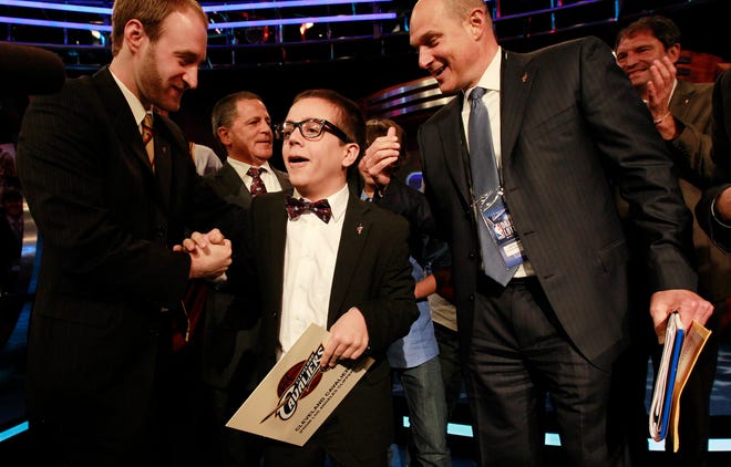 Fourteen-year-old Nick Gilbert (center), the son of Cleveland Cavaliers owner Dan Gilbert, celebrates moments after it was announced that Cleveland won the 2011 NBA basketball draft lottery Tuesday in Secaucus, N.J. Gilbert was the on-stage representative of the Cavaliers during the announcement.