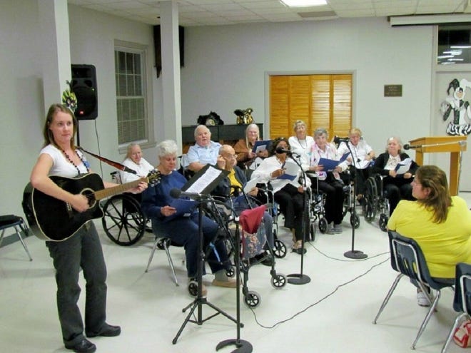 The Glee Club at Signature HealthCare of Orange Park practices, accompanied by Amanda Partlo, the nursing home's quality of life director and music therapist.