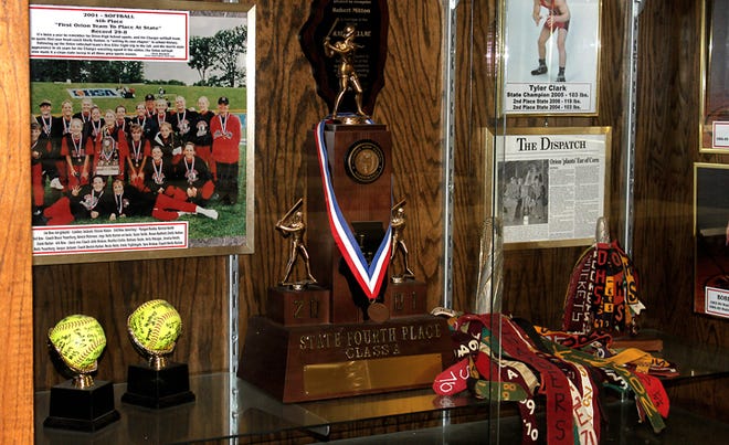 The fourth-place trophy from the state softball tournament in 2001, surrounded by other athletic memorabilia in a case in the commons at Orion High School.