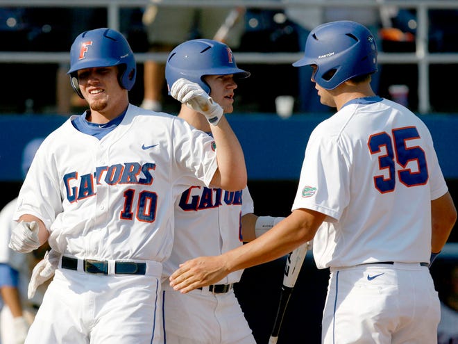 Florida batter Austin Maddox, left, is congratulated by Brian Johnson after hitting the first of his two home runs against Kentucky at McKethan Stadium on Saturday in Gainesville. Florida defeated Kentucky 19-3 to clinch a share of the SEC title with South Carolina and Vanderbilt.