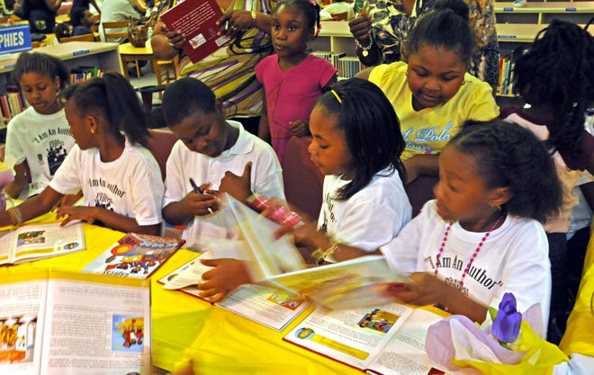 Fourth-graders at Martin Luther King Elementary School helped write a book, "The Writing Express," designed for preschoolers. They signed autographs at a publicity event.