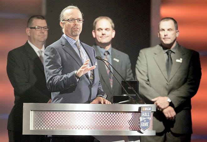 Kyle Petty, second from left, speaks as he helps induct his grandfather, Lee Petty, into the NASCAR Hall of Fame. Pictured from left to right are: Mark Petty, Tim Petty and Ritchie Petty, right, look on.