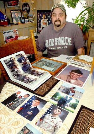 Raymond Gamache with photos of his late on TSgt. Jeremy Gamache.