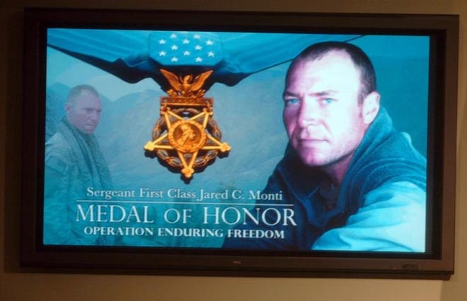 A television monitor at the Pentagon shows a collage in honor of Sgt. Jared Monti.