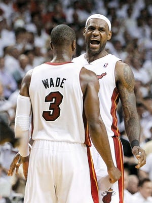 Heat teammates LeBron James and Dwyane Wade (3) celebrate their overtime win over the Chicago Bulls on Tuesday in Miami.