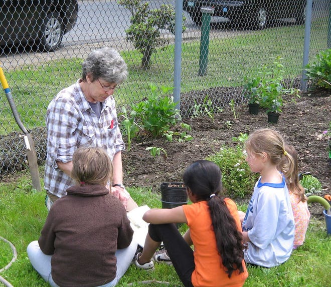Children helping Lois Bennett, Ashland Community Gardens' event coordinator.