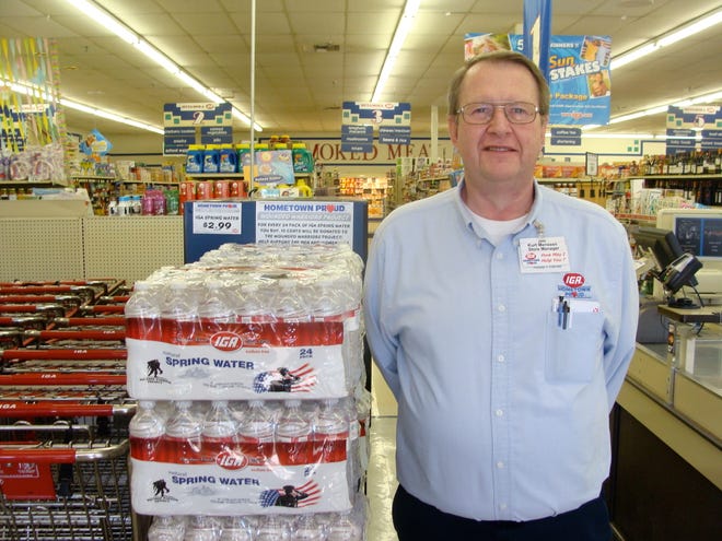 Kurt Menssen, Metamora IGA manager, poses with the water the store is selling that benefits the Wounded Warriors Project.