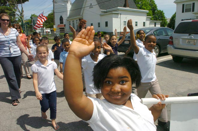 Six-year-old Caelle Michel practices her parade wave during rehearsal for the annual Memorial Day parade at the Huntington School in Brockton on Wednesday. The school’s 114th annual parade starts at 12:30 p.m. Friday.