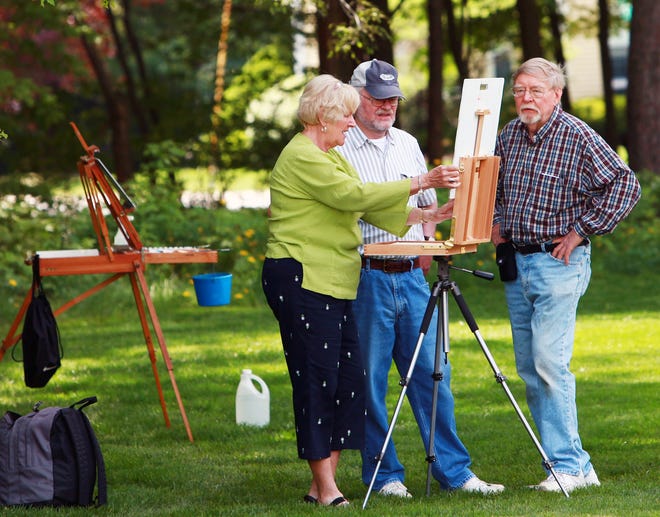 Sue Sheridan of Franklin, left, sets up her painter's easel under the watchful eyes of Paul Peterson of Medway and Dick Fotland of Franklin at the Franklin Art Association's annual art show on Saturday.