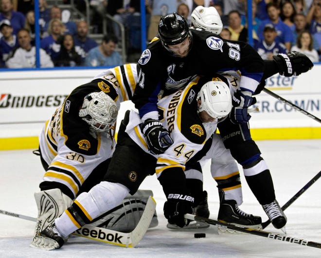 Tampa Bay Lightning's Steven Stamkos (91) gets tangled up with Boston Bruins' Tim Thomas, left, and Dennis Seidenberg (44), of Germany, while trying to get position on the puck during the second period in Game 6 of an NHL hockey Stanley Cup playoffs Eastern Conference final series in Tampa, Fla., Wednesday, May 25, 2011. (AP Photo/Chris O'Meara)