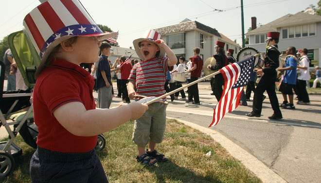 John Teeven, 3, shows his joy as the Belmont Memorial Day parade goes by. Holding his flag straight out is his brother Joe, 1. 05.31.10