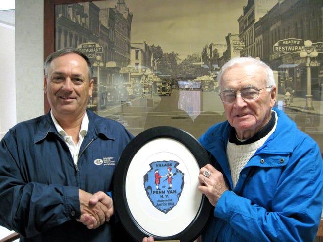 Mayor Robert Church accepts a reproduction of the Penn Yan seal artwork from Bob Reynolds, whose brother, Chuck, designed the original.