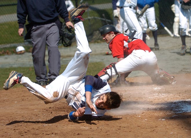 Gino Cresta of the Big Blue baseball team tumbles in a collision at the plate with the Saugus catcher during the April 18 game. 

USED IN PRINT 052611