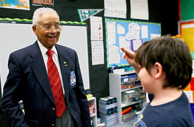 Col. Charles F. McGee receives a salute from Angel Hicks, 10, at Derby Ridge Elementary School on May 26. McGee, a member of the Tuskegee Airmen, and Capt. George Dunmore, a retired National Guardsman and distinguished honorary member of the Tuskegee Airmen, gave a talk to Derby Ridge third-graders about military service and the importance of values such as non-discrimination and discipline.