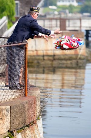 EJ Hersom/Staff photographer
Frank Desper, front, throws a wreath into the Piscataqua River with the help of Deborah DeMers Friday in honor of Memorial Day.