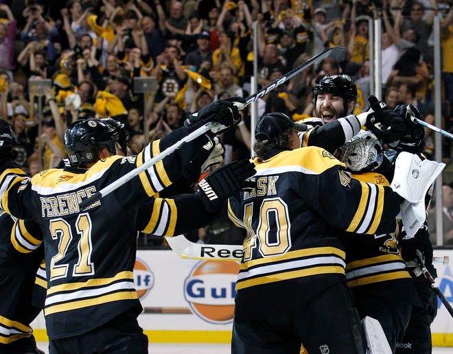 Bruins players, including defenseman Zdeno Chara, celebrate around goalie Tim Thomas after they defeated the Tampa Bay Lightning in Game 7 of the Eastern Conference finals.