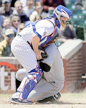 Chicago Cubs catcher Koyie Hill, left, tags out Pittsburgh Pirates runner Jose Tabata at home during the first inning of Friday's game in Chicago. AP Photo
