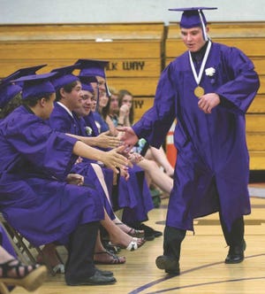 Valedictorian Christopher Hruby is congratulated by classmates after delivering his commencement address Friday night.