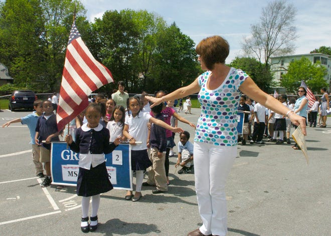 Huntington School second-grade teacher Jill Loftus shows her students how to be at arm’s length with each other during practice on Wednesday for the school’s Memorial Day parade on Friday in Brockton.