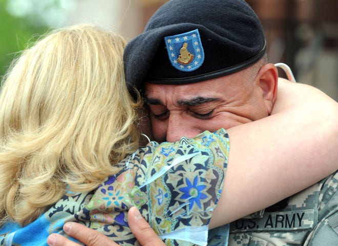 Angel Otiz,(uncle of Anthony) Brockton, active U.S. Army, right, is overcome with emotion as he is comforted by his sister Elise Feliciano, (aunt of Anthony) Brockton, during the plaque dedication.The Brockton Memorial Day Parade on Monday, May, 30, 2011. The parade concluded at City Hall Plaza with a special plaque dedication ceremony for United States Army Captain Anthony Palermo Jr. , Brockton, 18th Infantry Regiment, 2nd Brigade Combat Team, 1st Infantry Division, and attended Brockton High School, ans was killed while engaged in combat operations in Baghdad on April, 5, 2007.