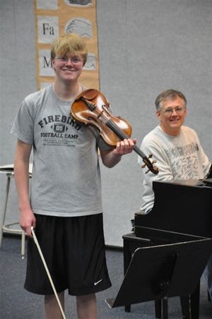 Ben Bergstrom and instructor Richard Neukom are shown practicing in the high school music room.