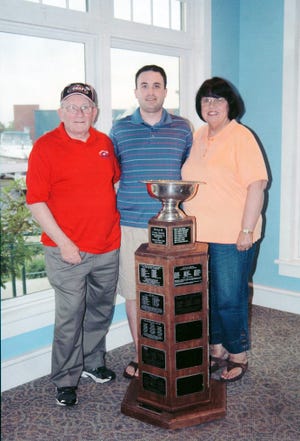 Brockton native Bobby Kinsella  shows off the Clark Cup to his parents, Bob and Joyce Kinsella, recently. Bobby Kinsella is an assistant coach and scout for the Fighting Saints, a United States Hockey League team based in Dubuque, Iowa, that recently won the cup by claiming the USHL title.