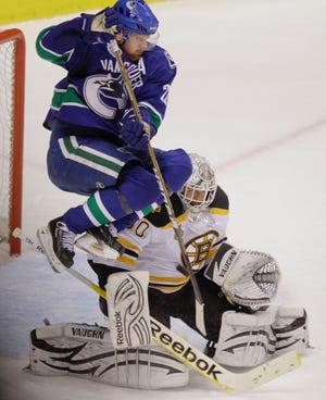Vancouver Canucks left wing Daniel Sedin leaps on a shot attempt as Boston Bruins goalie Tim Thomas makes a save in the third period during Game 1 of the NHL hockey Stanley Cup Finals, Wednesday, June 1, 2011, in Vancouver, British Columbia. The Canucks won 1-0.