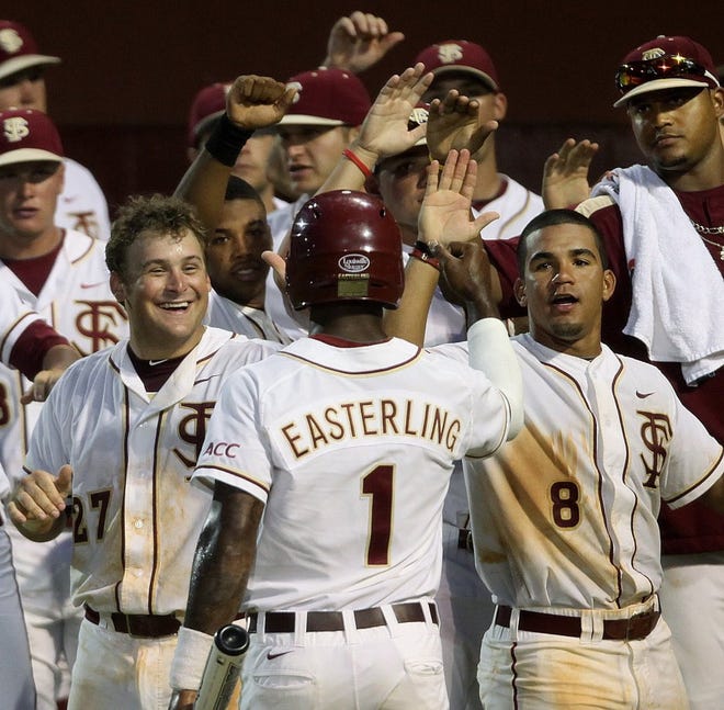 Stuart Tapley (left) and Devon Travis (right) welcome Taiwan Easterling (1) home with the winning run on Friday night against Bethune Cookman.