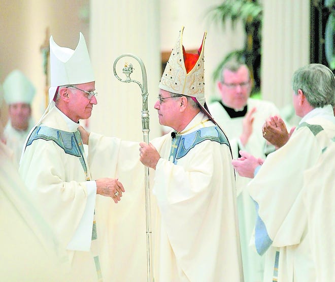 The Most Rev. Victor Galeone, left, Bishop Emeritus of St. Augustine, congratulates the Most Rev. Felipe J. Estevez on his installment as the 10th Bishop of the Diocese of St. Augustine at St. Joseph Catholic Church on Thursday in Jacksonville. By WILL DICKEY, Morris News Service