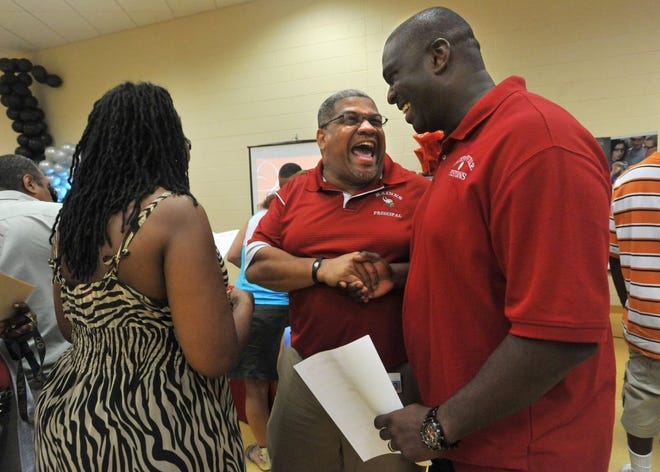 Alfred Aviles (left), lead teacher at Ribault's Academy of Finance, explains his program to Justin Williams and Selena Webster-Bass, Williams' science teacher at Northwestern Middle School.