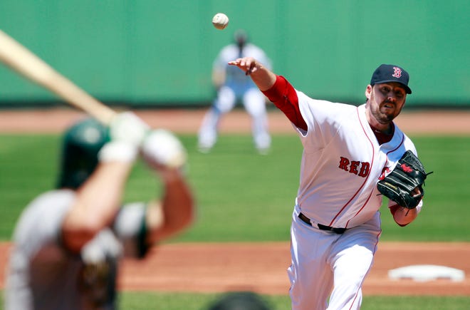 John Lackey pitches in the first inning of the Red Sox' 6-3 victory over the Oakland Athletics on Sunday.