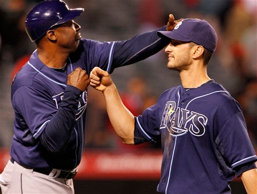 Tampa Bay Rays' Justin Ruggiano right, is congratulated by first base coach George Hendrick after a 5-1 win over the Los Angeles Angels in a baseball game in Anaheim Calif., on Monday, June 6, 2011.