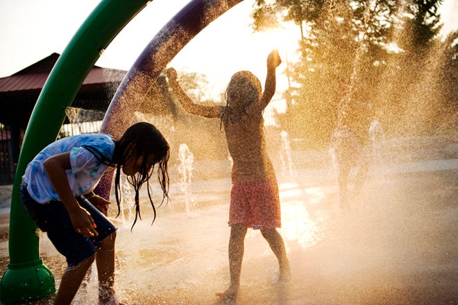 From left, sisters Isabella Sorm, 7, and Gabby Sorm, 6, play in the sprayground at the Douglass Family Aquatic Center at Douglass Park in Columbia on Thursday, June, 9, 2011.