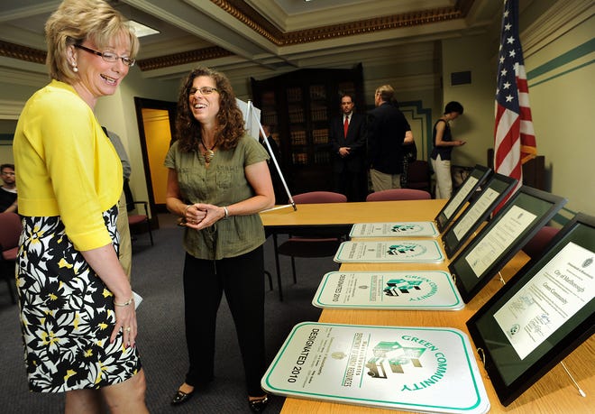 Mayor Nancy Stevens, left, and Joanna Bissetta, Green Community regional coordinator, look at Green Community signs that the city received Thursday.