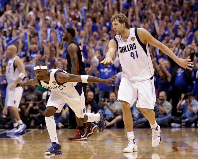 Dallas' Jason Terry (31) and Dirk Nowitzki (41) celebrate near the end of Game 5 of the NBA Finals last night.