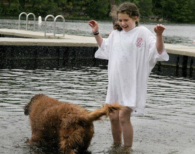 GRAFTON — Casey Campbell, 9, of Grafton braves cool temperatures yesterday to play in the water with her golden retriever, Jax, during the Hot Dippity Dog event at Silver Lake. The event has been happening for three years, and usually occurs at the end of the park’s season. This year, the event was planned for both the beginning and the end of the season.