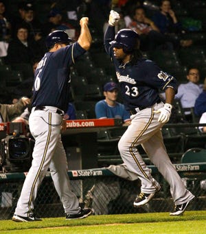 Milwaukee Brewers' Rickie Weeks celebrates his home run off Chicago Cubs relief pitcher John Grabow with Milwaukee Brewers third base coach Ed Sedar during the eighth inning of a baseball game and 9-5 win over the Chicago Cubs Wednesday, June 15, 2011 in Chicago.