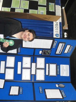 Dalia Martinez-Marin holds her fourth-place green ribbon next to her project in the 2011 Intel International Science and Engineering Fair in Los Angeles.