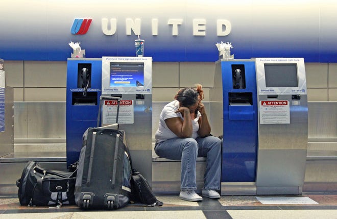 In this photo taken June 17, 2011, shows stranded United Airlines passenger Therell Churchill waiting at the United Airlines ticket counter at Denver International Airport Friday, June 17, 2011, in Denver. It could take several days for thousands of stranded travelers to get home after a United Airlines computer system shut down for several hours, leading to widespread cancellations Friday night. The unspecified "network connectivity" problem was fixed and flights resumed early Saturday, but the airline said delays could persist throughout the weekend.